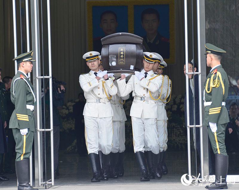 烈士孙络络的棺木被抬往殡仪车。
