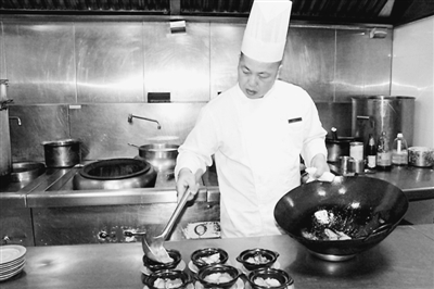 吴玉林师傅正在饭店的厨房烹饪菜品。本报记者 励 漪摄 站在18楼露台,黄浦江两岸上海标志性建筑尽收眼底。不过这里属于营业场地,我们很少过来。 我跟师傅住一起。我们无话不谈,谈烧菜,谈做人,像父子一样,甚至比父子还亲。 老家房子已经盖好了,三层楼。我家离大海很近,比起黄浦江,我更想念大海的味道。
