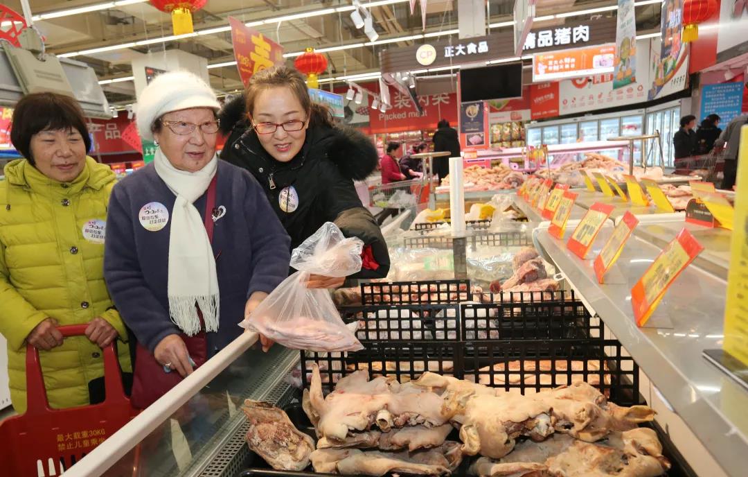 老人在志愿者陪同下到超市采购年货