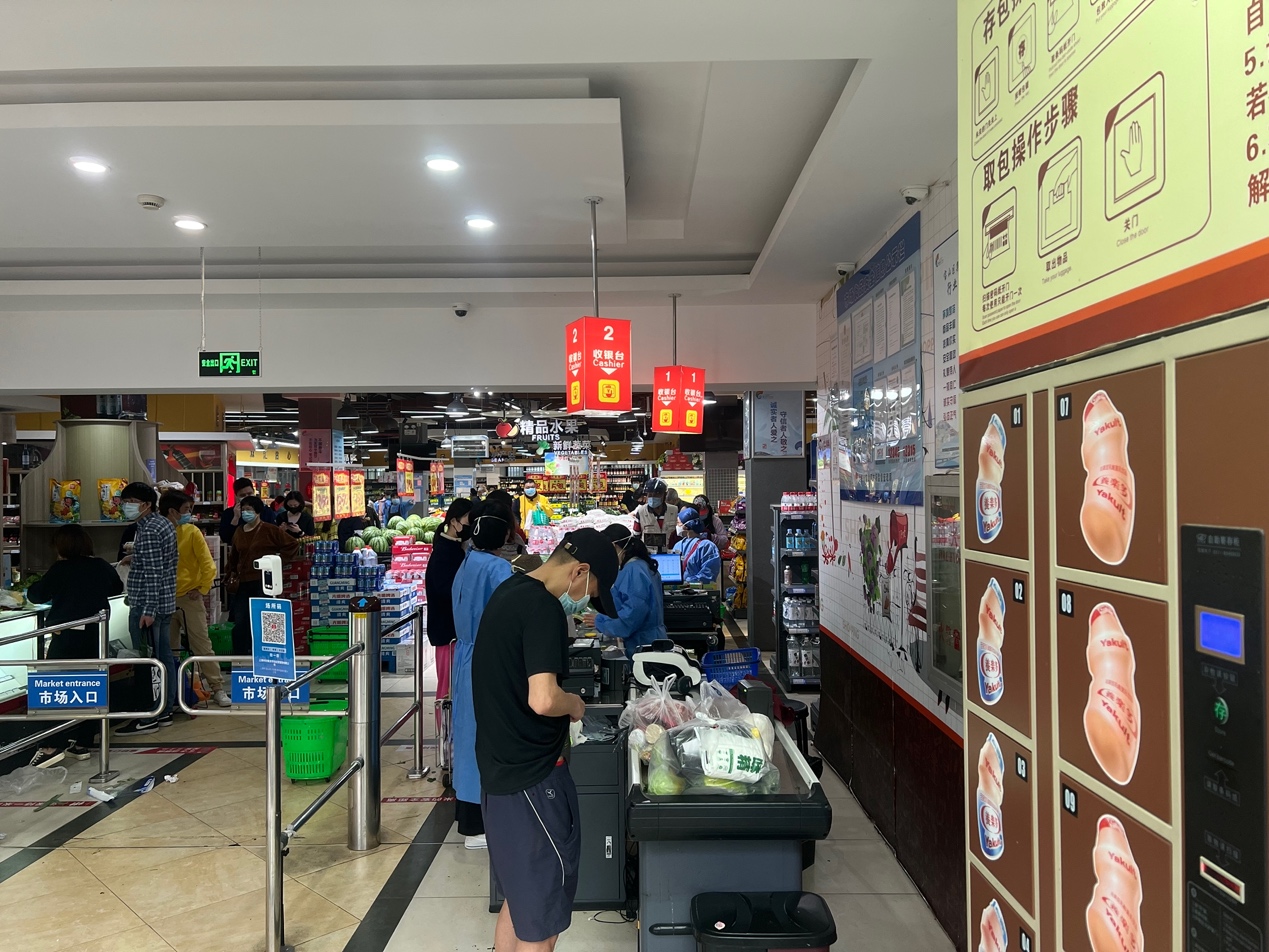 上海宝山，市民进入菜市场前需扫场所码和测温。马作鹏图