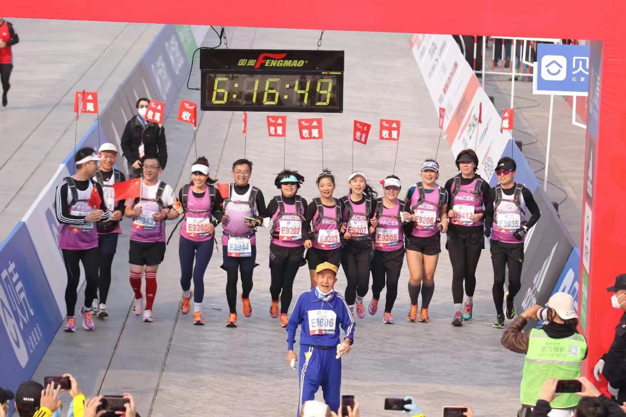 2022年北京马拉松，唐维红等“关门兔”陪同86岁跑者张顺完赛。北京马拉松组委会供图