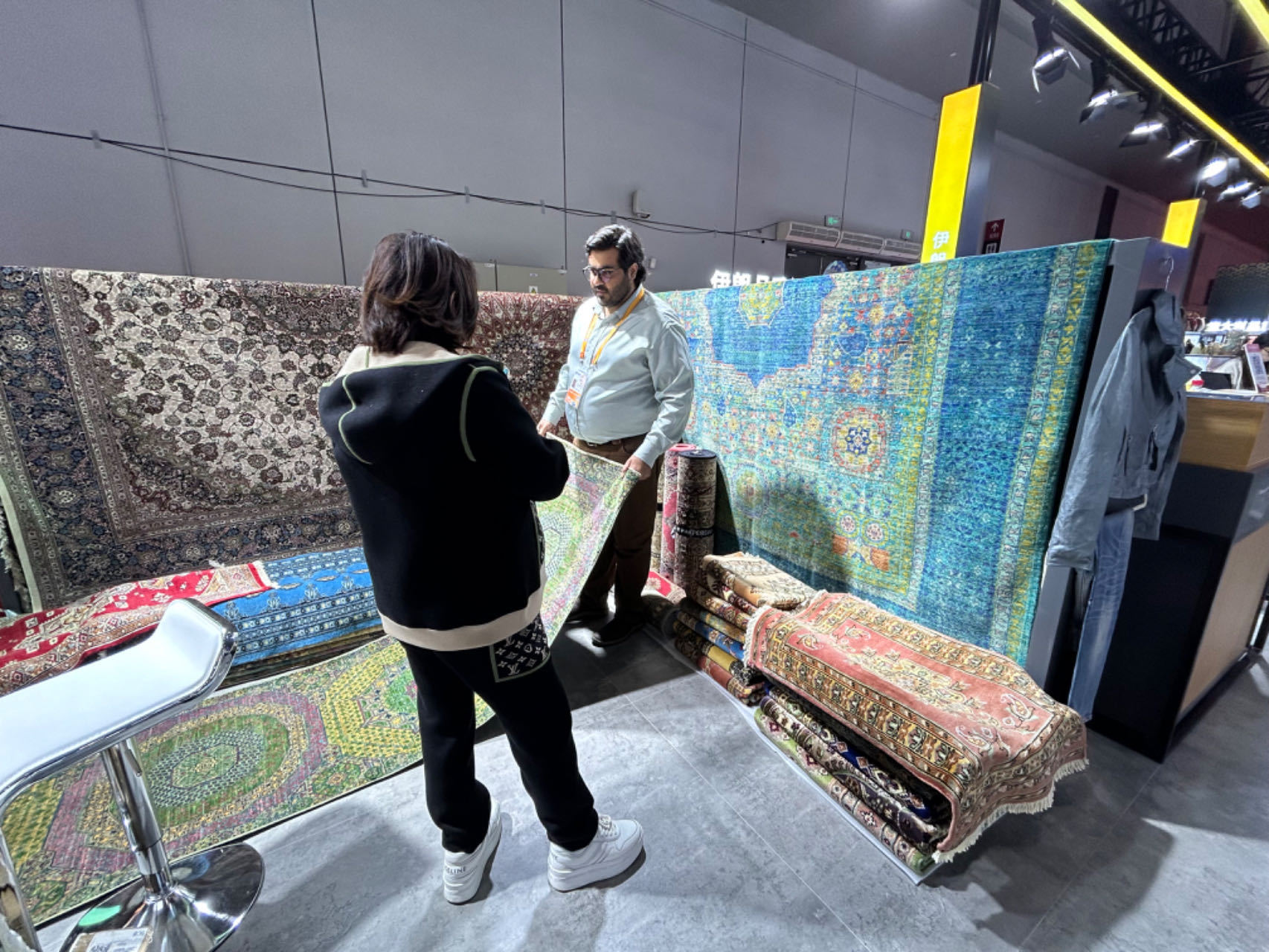 第六屆進博會上，巴基斯坦商人向觀眾介紹手工地毯。巨雲鵬攝