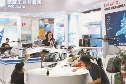 图为工作人员将上海时的科技自主研发的E20 eVTOL模型放上展台，第十届上交会布展工作昨天收尾。