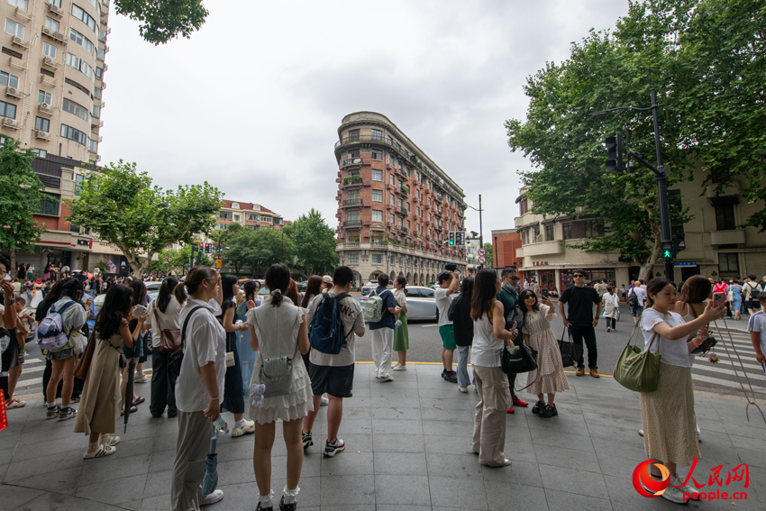 上海武康大樓前，不少游客駐足拍照留念。人民網記者 翁奇羽攝