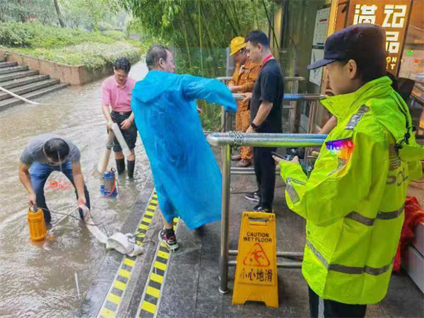 轨道公交总队人民广场站治安派出所民警在人民广场站17号口外雨水积压处组织车站工作人员抽水防止倒灌。