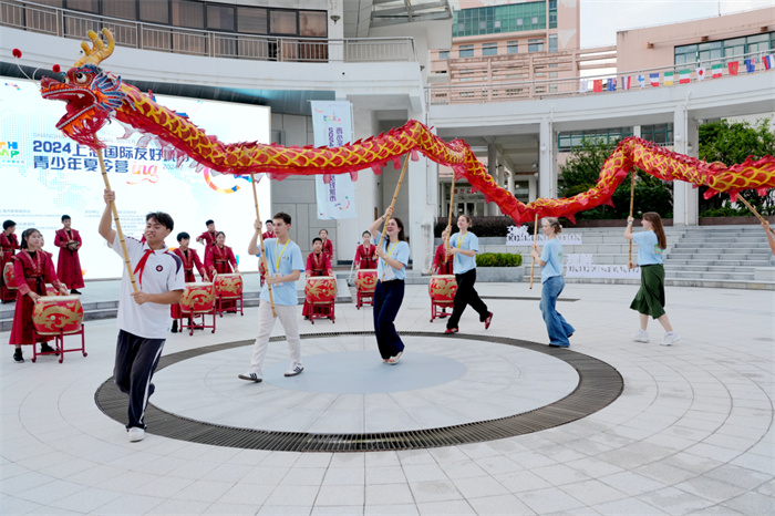 上海国际友好城市青少年夏令营成员在中国学生带领下体验舞龙。