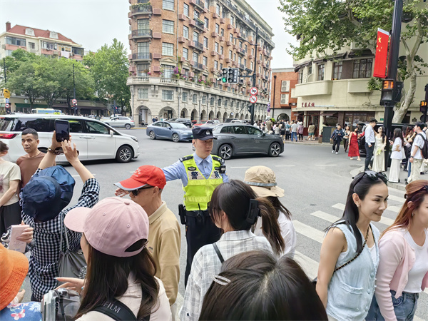 徐汇警方在武康大楼所在路口疏导人流、维持秩序。