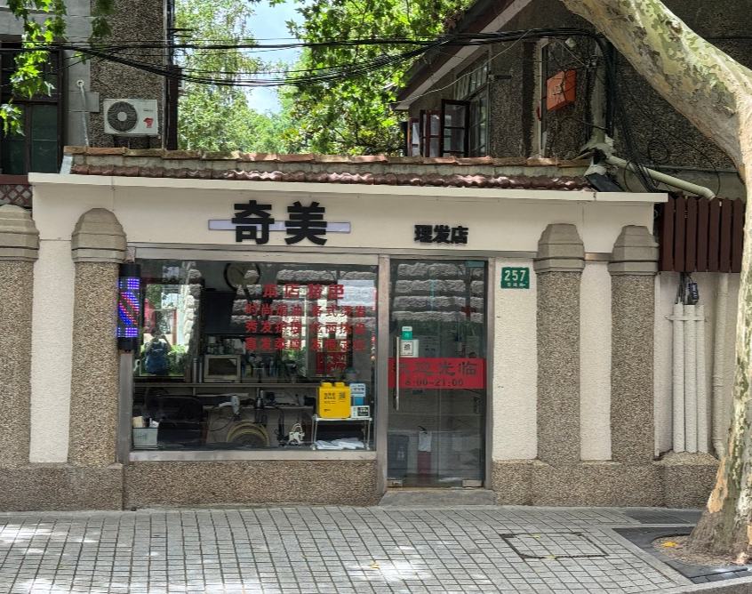 不推銷、不辦卡，這家安福路上的理發店靠什麼“扎根”30年？    安福路上，一家13平米的店面，兩面鏡子映著兩張軟椅，桌面和抽屜裡擁擠地放著各類洗護用品和理發工具。玻璃窗上貼著紅色字條講述“本店特色”，棕色招牌上“奇美理發店”這五個紅字，和30年前沒什麼兩樣，默默數著安福路的日升月落。