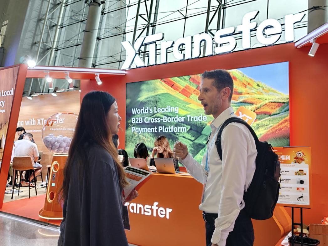 广交会现场，XTransfer展位工作人员为海外客商介绍跨境收款服务。人民网记者 王雅蝶摄