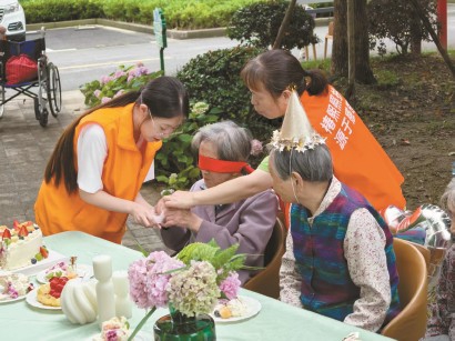 小金与同事在小花园里为老人们举办生日会。 资料图片