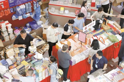 昨天，上海书展主会场上海展览中心，参展商加紧布置展台摆放图书。 记者 赖鑫琳 摄