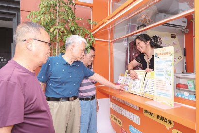 便民小车“大管家”许朝霞向居民介绍服务项目。  受访者供图