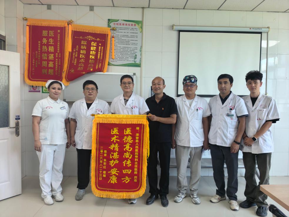 厉志（左三）收到患者送来的锦旗。受访者供图