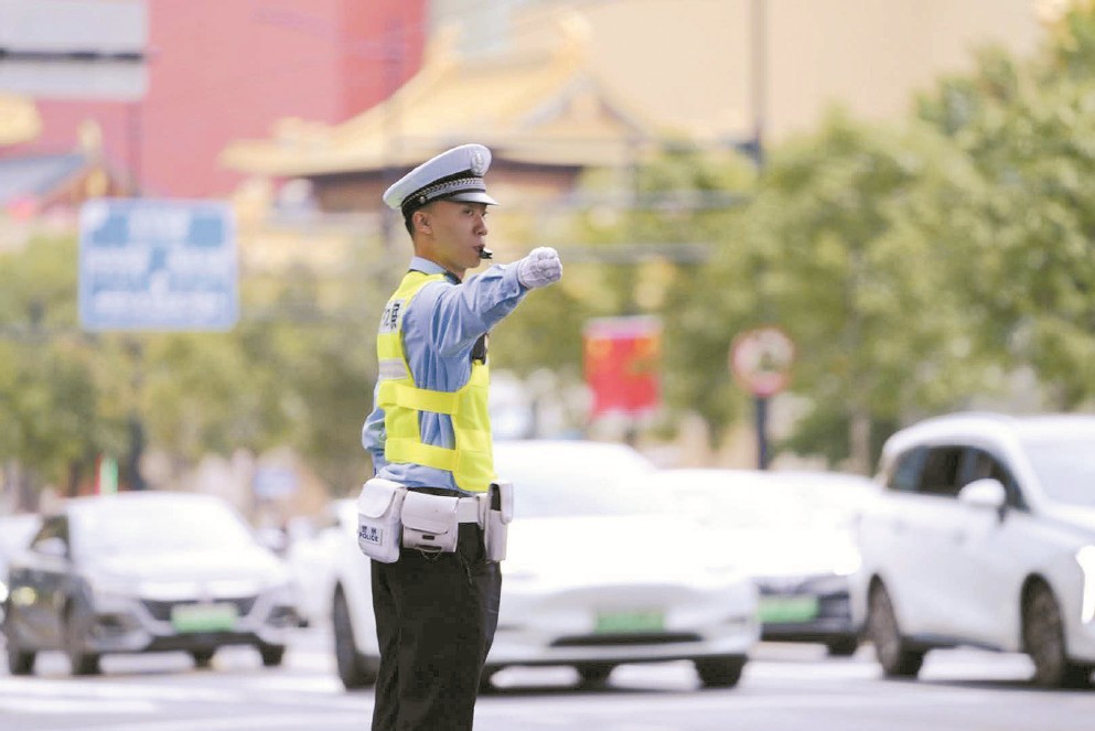 上海市公安局静安分局交管支队一大队民警汤淇鑫在延安中路华山路路口执勤。 （采访对象供图）