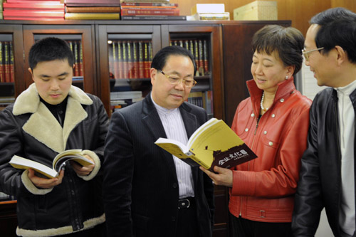 上海人民企业集团董事长金福音（中）与《企业文化地图》编辑在看新出版的图书